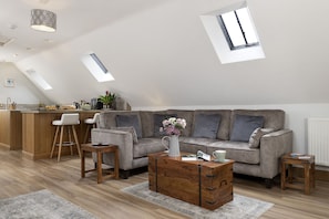 Un espace de vie de style loft comprenant un canapé, une table basse et un coin cuisine.