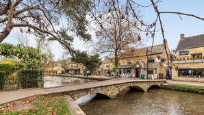 Un pont de pierre enjambant un canal, avec des bâtiments de chaque côté, dont un pub appelé « CROFT ».
