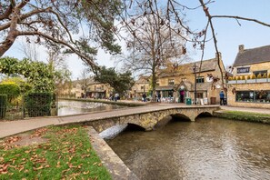 Un puente de piedra sobre un canal flanqueado por edificios, incluyendo un pub llamado 'CROFT'.