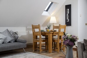 A dining area with a table, chairs, and a lamp.