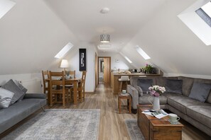 A modern loft apartment with a dining area, a living room, and a kitchen.