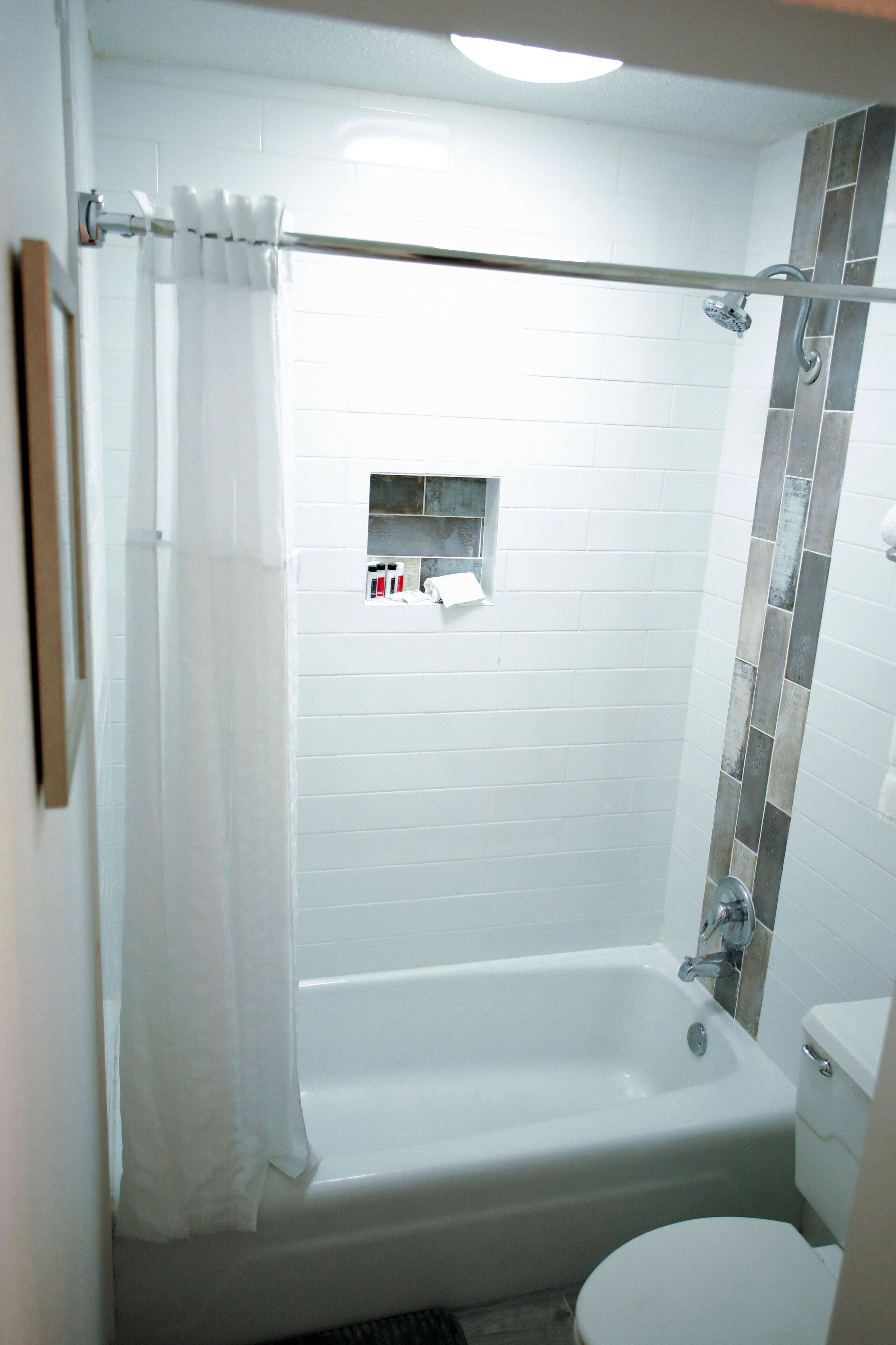 Un baño con bañera, inodoro y cortina de ducha.