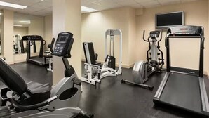 Ein Fitnessstudio mit Laufbändern, Crosstrainern und Kraftgeräten.