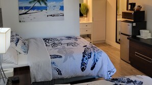 Ein Hotelzimmer mit Bett, Schreibtisch, Mikrowelle und Kühlschrank.