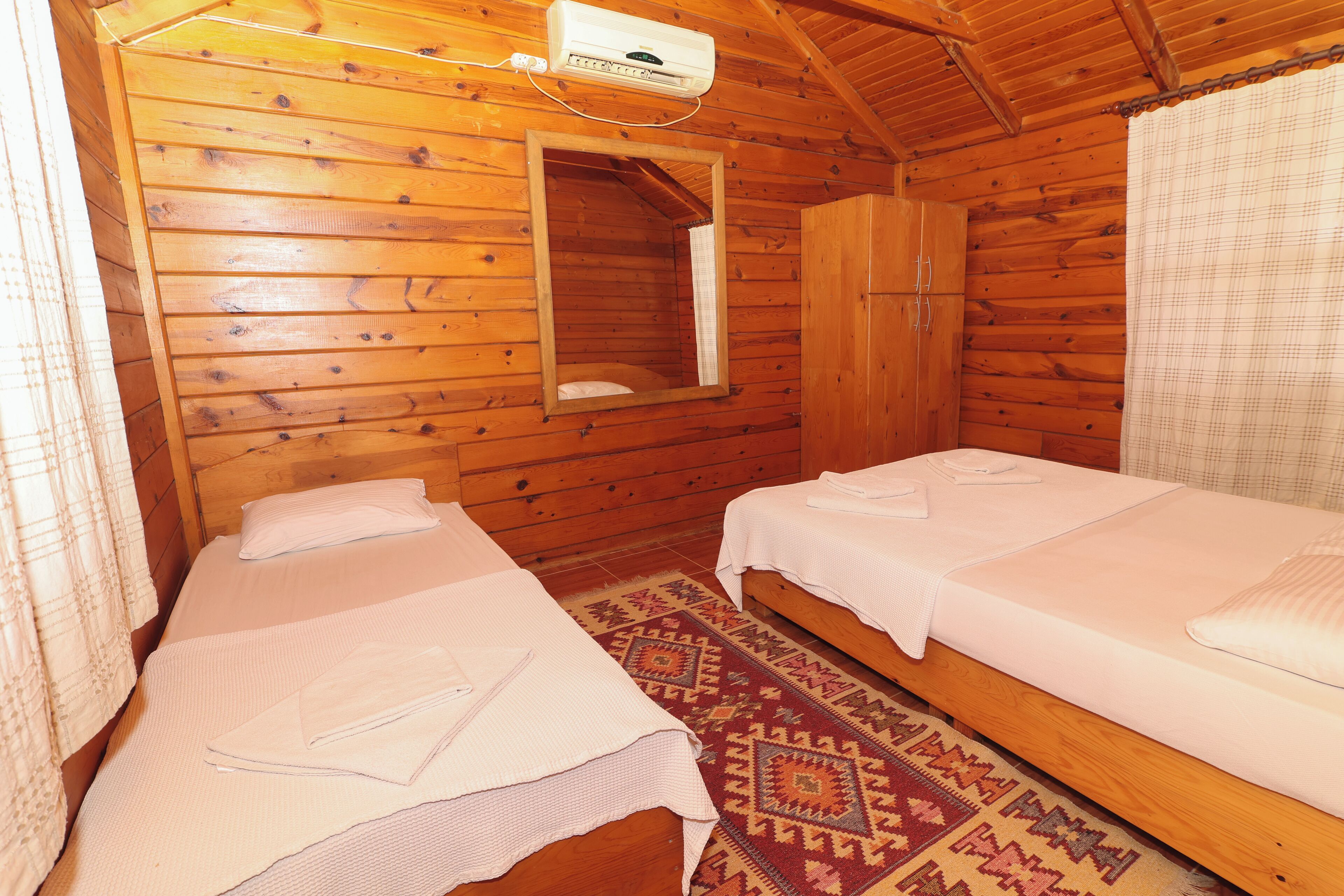 A cabin with two beds, a mirror, and a ceiling fan.