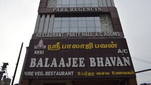 Un edificio con insegne per HP Towers, Park Regency e un ristorante chiamato Balaji Bhavan.