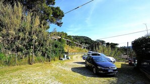 A gravel path with parked cars and a wooden fence. - Casa Terry B: A graceful apartment located right on the beach, with Free WI-FI. (Castellabate)