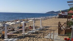 A beach with sun loungers and umbrellas, a rescue station, and a clear view of the sea and distant mountains. - Casa Terry B: A graceful apartment located right on the beach, with Free WI-FI. (Castellabate)