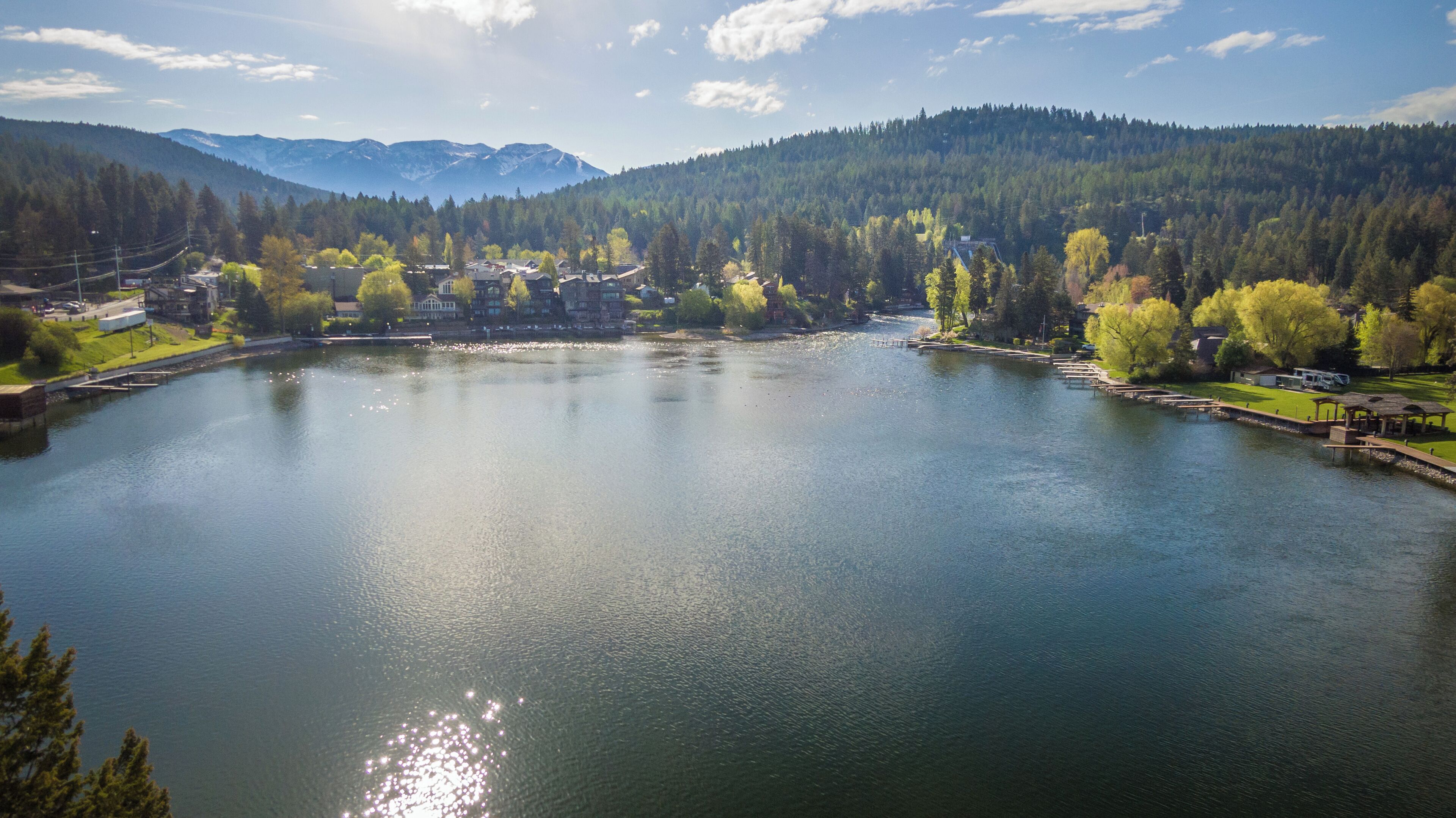 Ein See, umgeben von bewaldeten Hügeln und einer kleinen Stadt.