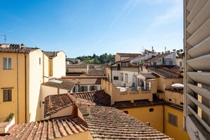 On aperçoit des toits recouverts de tuiles en terre cuite et des bâtiments jaunes, typiques d’une ville méditerranéenne.