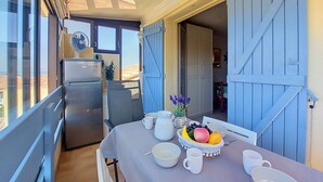 Comedor con mesa lista para el desayuno, un refrigerador y vistas al exterior.