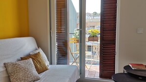 Ein Schlafzimmer mit Bett, Fenster und Blick ins Freie.