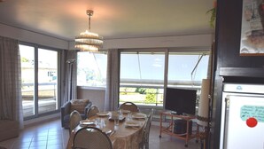 Comedor con una mesa lista para cuatro personas, televisión y refrigerador.