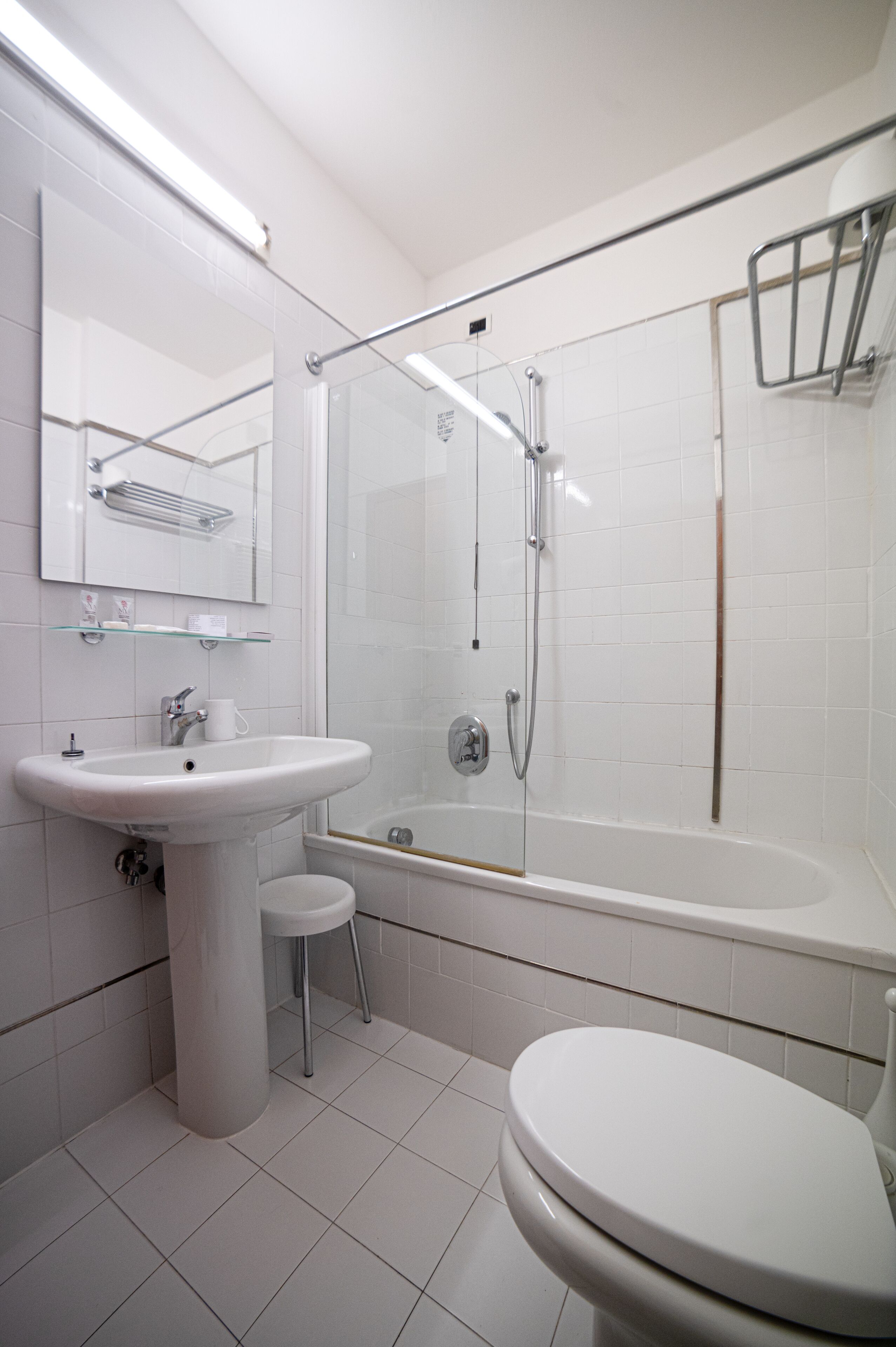 Un baño moderno con lavamanos, inodoro y bañera blancos.