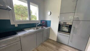 Una cucina moderna con mobili grigi, un lavello in acciaio inossidabile e un forno integrato.