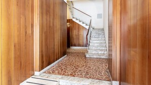 A wooden hallway leading to a staircase with a geometric patterned floor. - GuestHost - Ponte Solferino Bright & Cozy APT (Pisa)