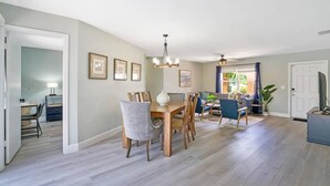 A spacious living area with a dining table, chairs, a sofa, and a ceiling fan. - Casa Boca - Perfect Florida Getaway with Large Heated Saltwater Pool (Boca Raton)