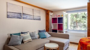 Un salon avec un canapé, une petite table ronde et une bibliothèque.