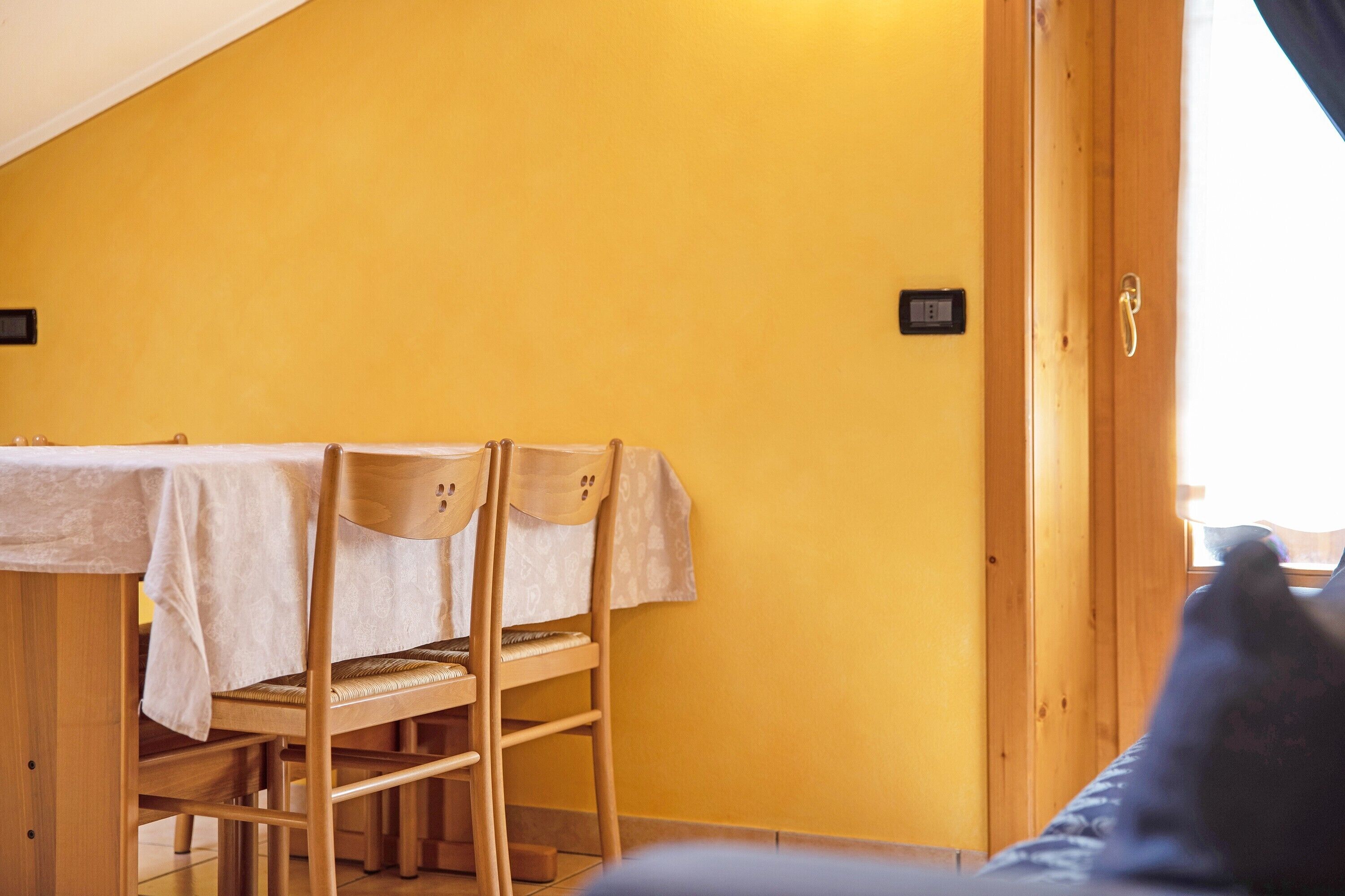 Una habitación con una mesa de comedor, sillas y una puerta de madera.
