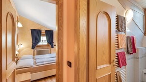 A room with a bed, a window with curtains, a radiator, and a wall-mounted towel rack. - 'Chalet Letizia Apartment Bilo' with Mountain View, Balcony & Wi-Fi (Livigno)
