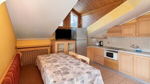 A compact kitchen with wooden cabinets, a refrigerator, a microwave, and a sink. - 'Chalet Letizia Apartments Trilo' with Mountain View, Balconies & Wi-Fi (Livigno)