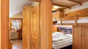 A wooden interior with a bunk bed, a wardrobe, and a radiator. - 'Chalet Letizia Apartments Trilo' with Mountain View, Balconies & Wi-Fi (Livigno)