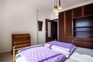 Een slaapkamer met een bed, een ladekast, een garderobe en een spiegel.