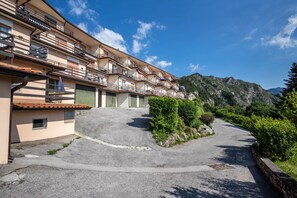 Un hôtel à plusieurs étages doté de balcons, d’un parking et situé dans un cadre montagneux.