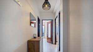 A hallway with a wooden cabinet, a mirror, and a hanging light fixture. - Apartment 'with Stunning Views' and Balcony (Tremosine)