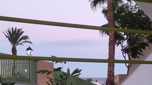 Un espace extérieur moderne doté d’un escalier, de palmiers et offrant une vue sur la mer.