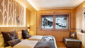 Una habitación acogedora con una cama, un ventanal y vistas a un paisaje nevado.