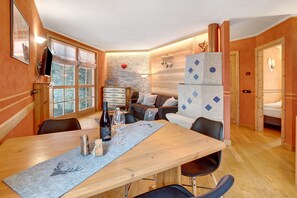 A cozy room with a wooden dining table, a sofa, and a fireplace.