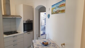 A compact kitchen with a stove, oven, and a dining area with a table and chairs.