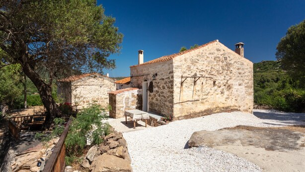 A stone building with a tiled roof, a bench, and a gravel path. - Holiday Home 'Stazzu Saiacciu' with Terrace (Palau)