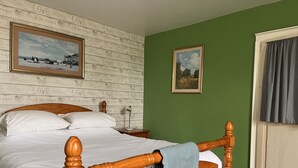 A bedroom with a wooden four-poster bed, white bedding, a green wall, and two framed pictures. - Gite La Maison du Passeur (Availles-Limouzine)