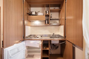 Uma cozinha compacta com fogão embutido, pia e armários para armazenamento.