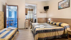 Une chambre d’hôtel avec deux lits, un bureau, une chaise, une salle de bain et un tableau au mur.