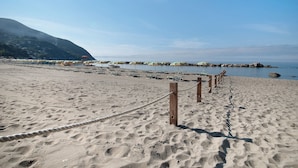 A sandy beach with a rope barrier, wooden posts, and a clear sky. - Apartment Bilocale Moneglia 31 close to the Beach with Shared Pool & Wi-Fi (Moneglia)