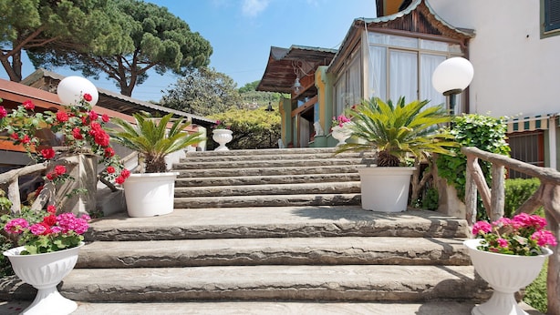 A stone staircase leading to a building with a traditional architectural style, surrounded by potted plants and a clear sky. - Apartment Bilocale Moneglia 31 close to the Beach with Shared Pool & Wi-Fi (Moneglia)