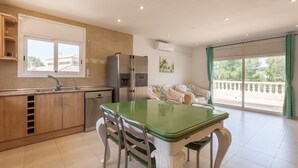 Une cuisine moderne avec un coin repas, un réfrigérateur, un lave-vaisselle et une fenêtre donnant sur un beau paysage.