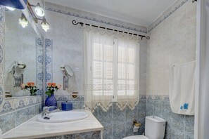 Ein Badezimmer mit Waschbecken, Spiegel, Toilette und dekorativen Fliesen.
