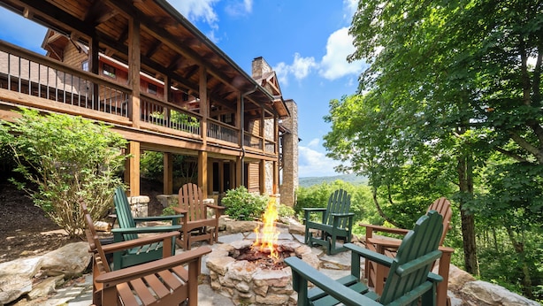 A lodge with a stone fire pit, green Adirondack chairs, and a view of the mountains. - Breezeway Lodge at Eagles Nest - hot tub, huge views, all Suite style rooms, close to tennis (Banner Elk)