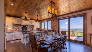 A spacious kitchen with wooden ceiling, large windows, and a dining area with a view of the mountains. - Breezeway Lodge at Eagles Nest - hot tub, huge views, all Suite style rooms, close to tennis (Banner Elk)
