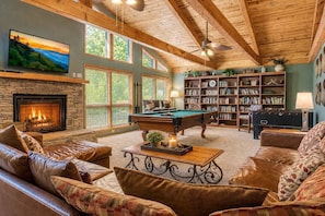 A cozy living room with a fireplace, pool table, leather sofas, and a bookshelf. - Mountain Lake Lodge Pool Table, Hot Tub, $560 FREE tickets each paid day! (Sevierville)