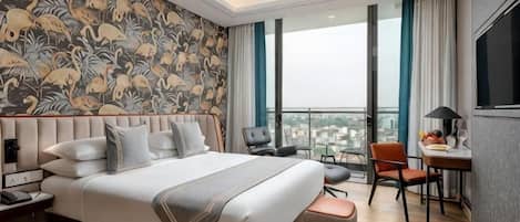 Habitación de hotel con una cama grande, un escritorio, una silla y vistas a la ciudad.