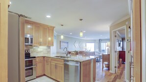 Una cocina moderna con armarios de madera, electrodomésticos de acero inoxidable y una isla central.