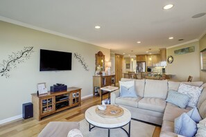 A living room with a sofa, coffee table, TV, and wooden entertainment unit.