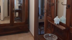 Ein Zimmer mit einem Holzschrank, einem großen Spiegel und einer Chandelüster.