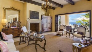 A spacious living room with a fireplace, elegant furniture, and a view of the ocean. - Pedregal Luca incredible Views with onsite staff (Cabo San Lucas)