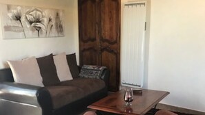 Un salon avec un canapé en cuir marron, une table basse en bois et un fauteuil marron.